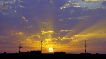 landscape of Sunrise with beautiful beams at colorful sky above roof