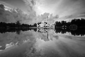 distant view of building near lake in black and white background