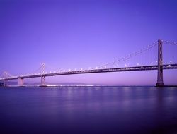 suspension bridge over the river at colorful dusk in the sky