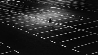 distant view of a lonely man among the parking at night