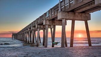 sunset over the pier on the ocean