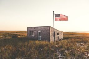 American flag near the house on the field on beautiful landscape