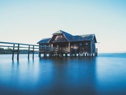 wooden house with boardwalk on calm water