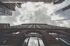 Skyscrapers at grey cloudy sky, bottom view