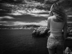 black and white photo of a girl on a rocky shore in Monaco