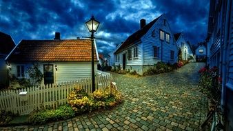 small houses along the stone road at night