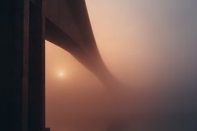 sunset over the bridge in the fog