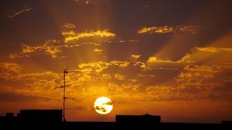 Orange beautiful sunset in the clouds above the city