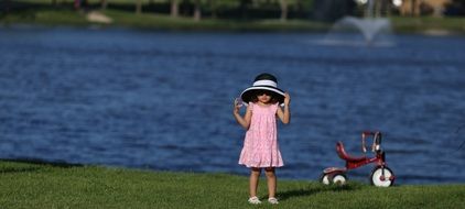 little girl and red squirrel on the shore of a reservoir in Towne Lake