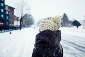 girl stands with her back against the winter landscape