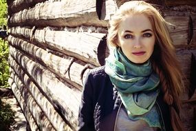 Portrait of the girl near the log construction among the plants