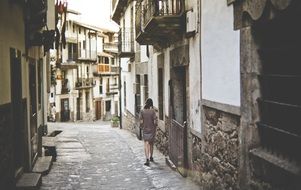 girl walks along a narrow old street