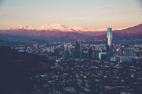 panorama of the city at the foot of snowy mountains