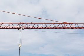 crane arm with load rope at cloudy sky
