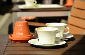 two white expresso cups in a street cafe