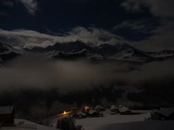 panorama of a snowy village in the mountains at night