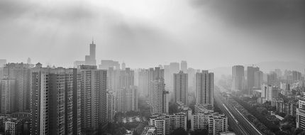 black and white photo of city skyscrapers in the fog