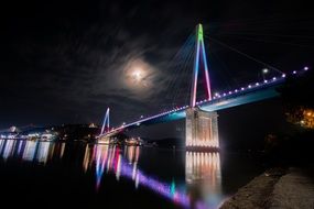 landscape of colorful bridge reflected in the water at night