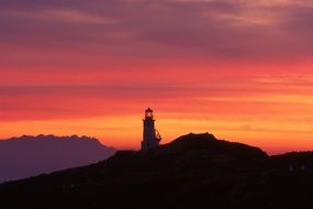 lighthouse on a background of orange-pink sunset