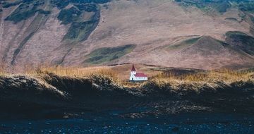 distant view of the church at the foot of the mountains