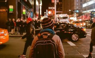 many people and cars on the streets of the night city