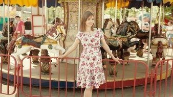 girl near a carousel in a city park