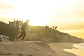 surfer in wetsuit on the sea beach