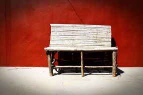 wooden bench at the red wall