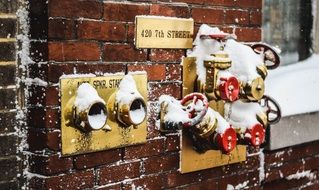 Snow on terminal of emergency on brick wall