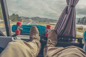 Traveling in Bus at countryside, male legs and scateboard at window, New Zealand