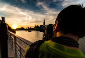 photographer takes pictures on Polaroid sunset over the river