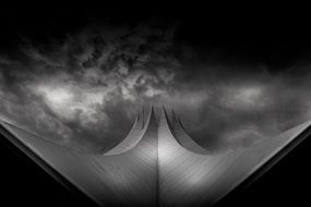 monochrome photo of futuristic roof construction at dramatic clouds, germany, berlin