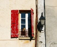 old red window shutters in France