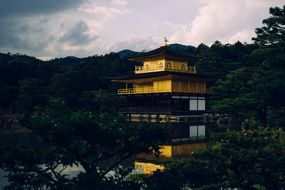 yellow buddhist temple at water in garden at dusk