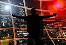 man spread his hands at the window with a city panorama drawing