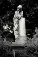 Black and white statue of a girl in a cemetery