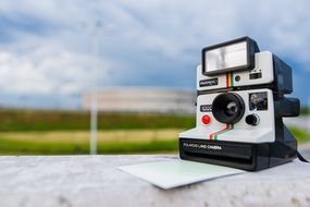 Polaroid camera with a photo on the concrete