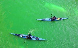 two blue canoes on green water