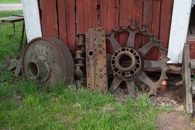 rusty wheels stand near the wooden wall