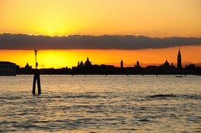 distant view from water to venice at sunset