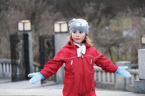 little girl in a red jacket on the street
