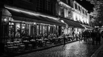 black and white photo of parisian street at night