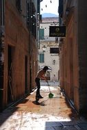 woman sweeping the street