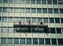 window washers on the facade of the building