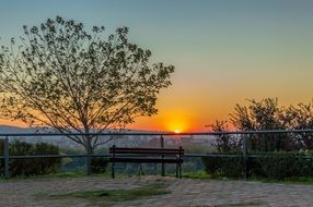 bench near the fence at sunset