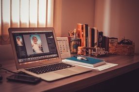 Apple Mac, notebook and books on desktop