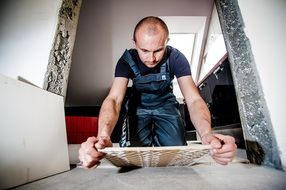 man covering of floor by tiles