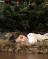 nice caucasian Child Girl lying on floor at christmas tree