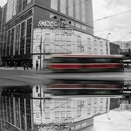 Black and white photo of the buildings with the colorful tram in motion in amazing Toronto, Canada