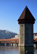 photo of a wooden bridge and tower in Switzerland